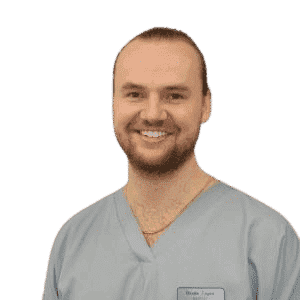 A man in scrubs smiling for the camera.